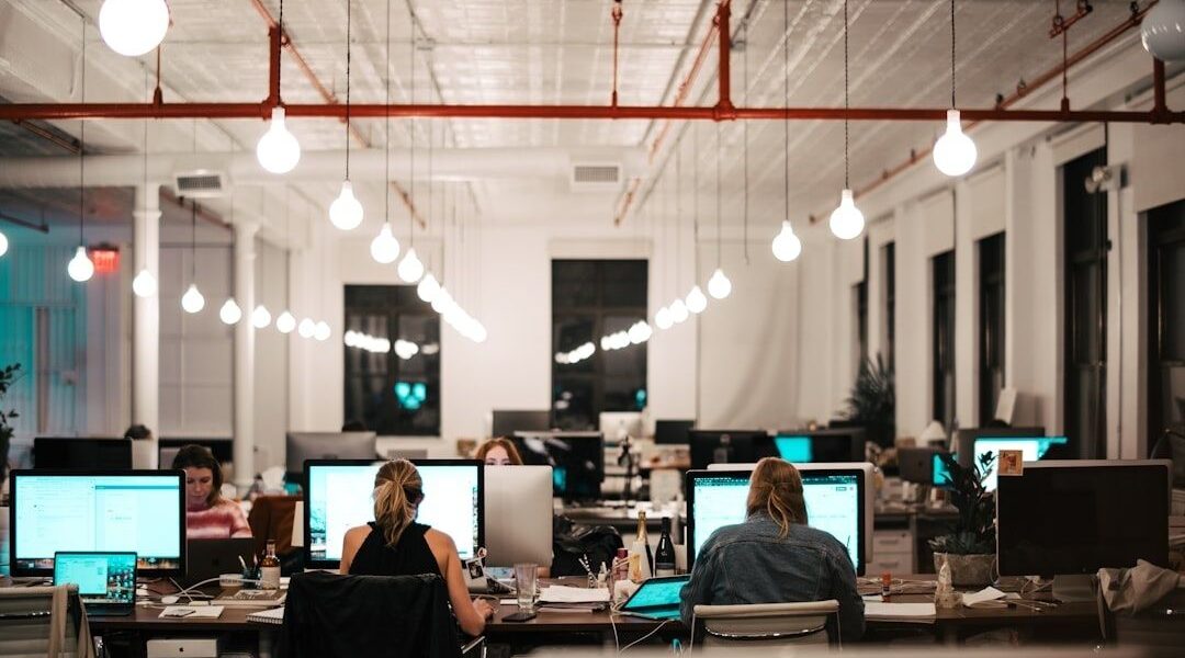 Öppet kontor med medarbetare och datorskärmar vid arbetsplatser