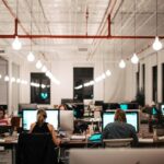 Öppet kontor med medarbetare och datorskärmar vid arbetsplatser