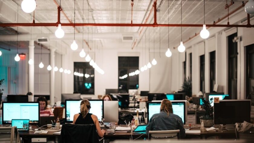 Öppet kontor med medarbetare och datorskärmar vid arbetsplatser